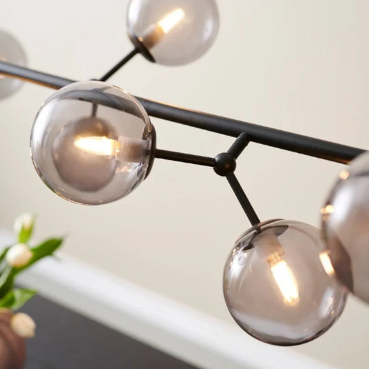 Pendellampa rökglas Atom 123 cm över matbord