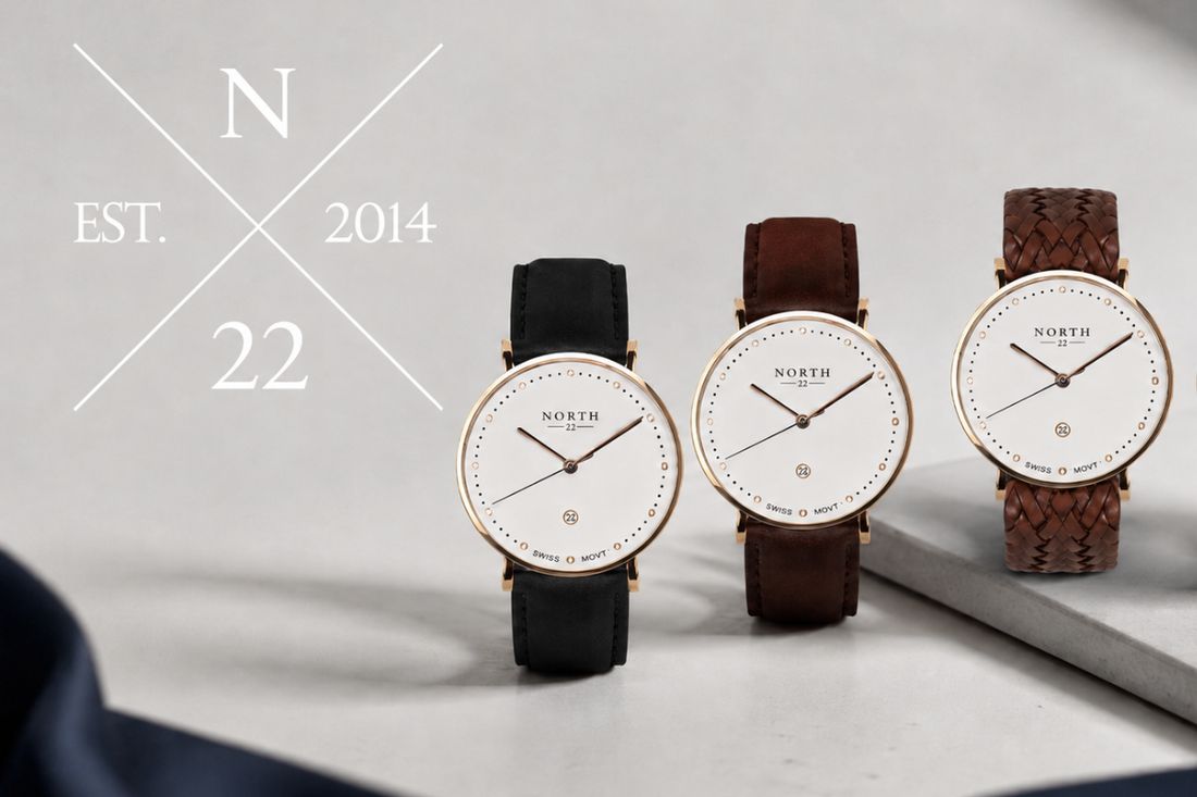 North Twentytwo-logotyp N 22 est. 2014 bredvid tre armbandsur med vit urtavla och guldfärgad boett, med svart, brunt och flätat läderarmband